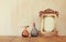 Image of victorian vintage antique classical frame and perfume bottles on wooden table. filtered image