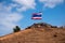 Image of waving Thai flag of Thailand with blue sky and mountain