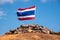 Image of waving Thai flag of Thailand with blue sky and mountain