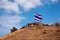 Image of waving Thai flag of Thailand with blue sky and mountain