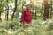 Image of well organised handsome old tourist being alone in forest, spending his free time with pleasure, having pleasant facial