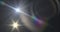 Image of white light with beam and prismatic lens flare on dark background
