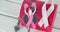 Image of woma in boxing gloves icon over pink box and ribbon on white wooden background