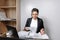 Image of a woman jotting down notes while sitting at a desk in an office. A girl working with papers in an office. Real