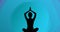 Image of woman meditating silhouette on blue background