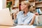 Image of woman using earphones and singing while working with laptop