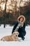 Image of woman on walk with dog on background of trees in winter