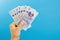 Image womans hands which holds British pounds in her hands isolated over blue studio background