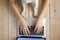 Image of womanâ€™s hands typing fast on laptop keyboard with dogâ€™s paws on same tabletop. View from above. Remote work from home