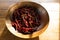 Image of wooden bowl with red dry chili peppers