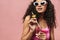 Image of young african american woman in sunglasses drinking champagne