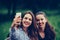 Image of young amazing women friends, students sitting in the park make selfie by mobile phone