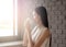 Image of young and pretty asia woman with cup of coffee and looking out the window