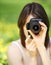 Image of young woman photographing in summer park