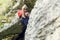 Image of young woman in red helmet climbing on rock