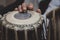 Images of a man`s hands wearing beads playing the Tabla. -