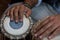 Images of a man`s hands wearing beads playing the Tabla. -