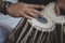 Images of a man`s hands wearing beads playing the Tabla. -