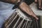 Images of a man`s hands wearing beads playing the Tabla. -