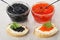 Imitation red and black caviar and spoons in bowls, sandwiches