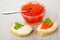 Imitation red caviar and spoon in bowl, sandwiches with butter