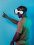 Immersed in a digital realm, an African American man navigates the virtual landscape with a VR goggles, using tactile