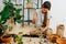 Immersed happy woman filling glass bottle with artificial clay stones