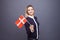 Immigration and the study of foreign languages, concept. A young smiling woman with a Denmark flag in her hand.