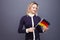 Immigration and the study of foreign languages, concept. A young smiling woman with a Germany flag in her hand.