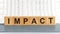 Impact word written on wood block. impact text on table, concept