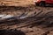 Impassable dirt on the road, an obstacle for a car on a forest road, a blurred ground under the wheel of a car