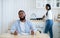 Impatient hungry black husband waiting for dinner with empty plate, looking bored