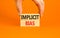 Implicit bias symbol. Concept words Implicit bias on wooden block. Beautiful orange table orange background. Businessman hand.