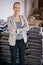 We import the best of the best. Portrait of a young woman standing by bags of coffee in a distribution warehouse.