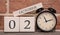 Important date, October 2, autumn season. Calendar made of wood on a background of a brick wall. Retro alarm clock as a time