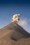 Imposing active volcano making an incredible and strong eruption with an ash cloud that rises in a blue sky on a sunny morning