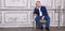 Imposing mature man in elegant suit sitting on a leather chair in a modern luxurious interior. Fashion. Business.