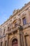 Imposing stone building with grand arches and a door in Mdina Old City Fortress