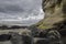 An imposing weathered cliff on a beach