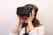 An impressed, surprised, flabbergasted woman taking off or putting on Oculus Rift VR virtual reality headset