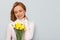 Impressed young woman doesn`t expect to get beautiful bouquet of daffodils flowers from her boyfriend