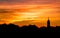 Impressive church against a majestic mountain range, illuminated by the warm sunset