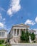 The impressive curved marble stairs and neo-classical facade of the national library with a Greek flag on top.