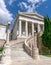 The impressive curved marble stairs and neo-classical facade of the national library with a Greek flag on top.