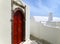 Impressive Greek Style Door Casing with Deep Red Door on Pure White Building at Santorini