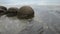 Impressive Moeraki boulders in the Pacific Ocean waves