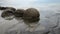 Impressive Moeraki boulders in the Pacific Ocean waves