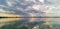 Impressive panorama majestic dramatic urban evening storm with gloomy clouds and rain over lake.