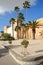 The impressive ramparts of the medina surrounded by colorful palmtrees and a large cobbled walkway in Sfax