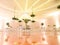 IMPRESSIVE RECEPTION VENUE WITH BEAUTIFUL WHITE  WEDDING CAKE AT CANDY TABLES, FLORAL GREEN DECORATION, REFLECTIVE FLOOR, BLURRED